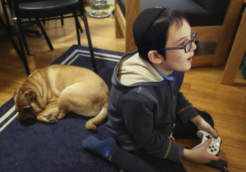 In this Dec. 30, 2019, photo, Gavriel Menachem Blum, 10, plays a video game before Shabbat dinner at his family’s home in New York. Like many Jews who observe Sabbath, Blum refrains from playing video games and using other electronics after sundown. (AP Photo/Jessie Wardarski)