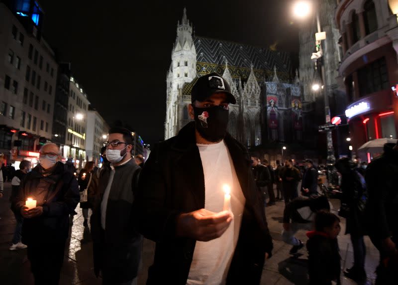 People hold candles outside St. Stephen's cathedral, following a religious mass for the victims of a gun attack in Vienna