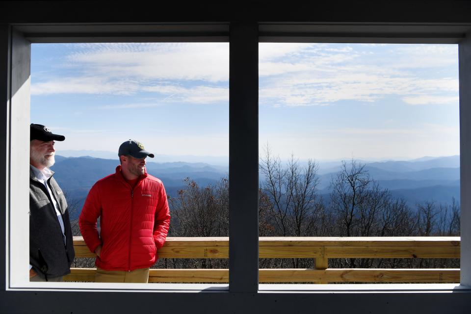 Morgan Sommerville, the southern regional director of the Appalachian Trail Conservancy, and Peter Barr, coordinator of the North Carolina chapter of the Forest Fire Lookout Association, take in the view atop the newly restored Rich Mountain lookout tower near Hot Springs Nov. 19, 2018.