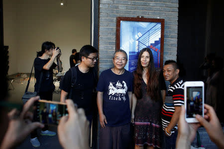 Artists Noah Ng Fong Chao (L), Beate Linne (2nd R) and Satadru Sovan (R) pose for pictures with the organiser Chen Jin at the OPEN international performance art festival in the Songzhuang art colony outside Beijing, China, September 22, 2017. REUTERS/Thomas Peter