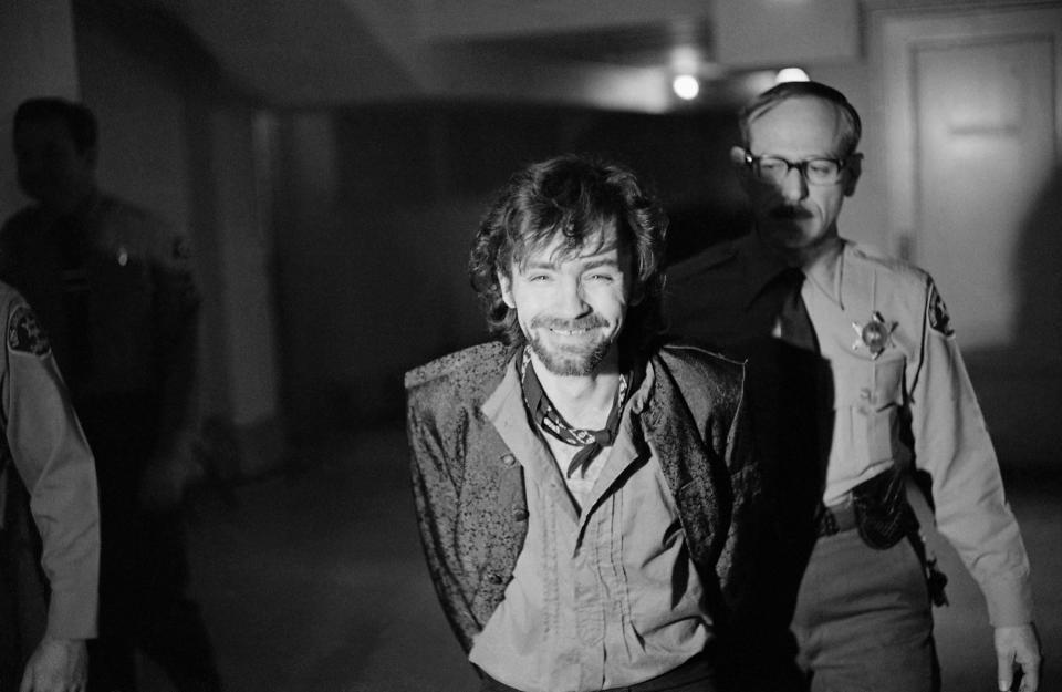 <p>A smiling Charles Manson goes to lunch after an outbreak in court that resulted in his ejection, along with three women co-defendants, from the Tate murder trial on Dec. 21, 1970. The outburst started after Leslie Van Houten said she wanted to fire her new lawyer, a replacement for missing Ronald Hughes, and hire a woman attorney. Before she was ejected to an adjoining room with the others, Ms. Van Houten slapped a bailiff and told the judge, “I’d strike you if I could.” (Photo: George Brich/AP) </p>