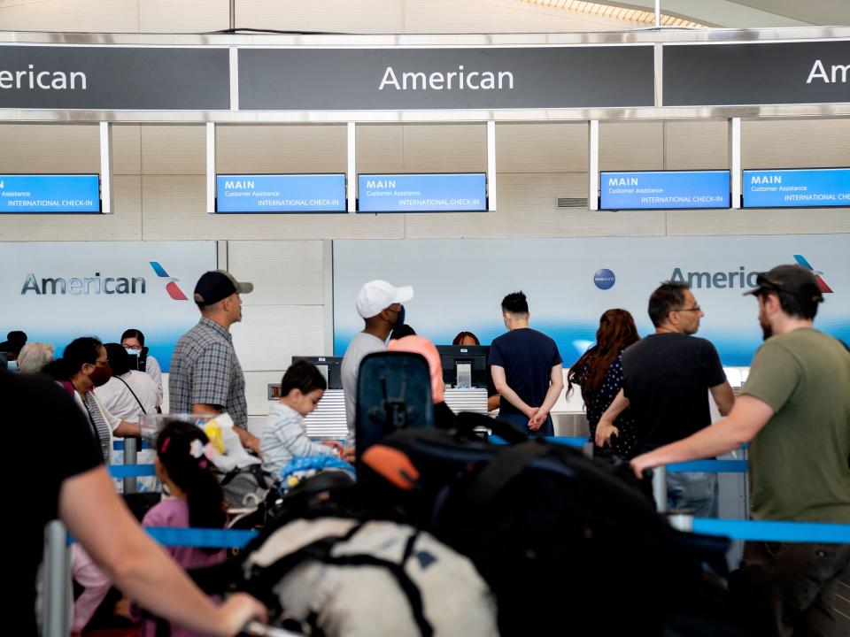 Travelers wait in line at an American Airlines counter at Ronald Reagan Washington National Airport in Arlington, Virginia, on July 2, 2022