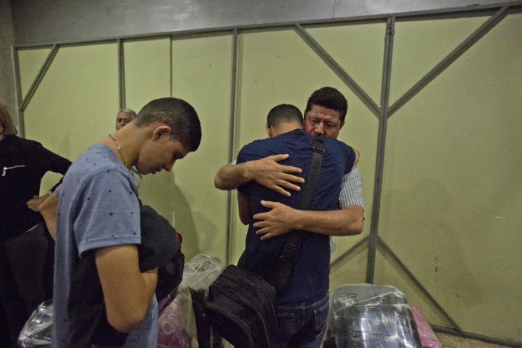 Ermidez García abraza a su hijo José Luis antes de que se marche con su hijo a Bogotá, Colombia, en el Aeropuerto Internacional Simón Bolivar, en Maiquetia, Venezuela. (AP Photo/Fernando Llano)