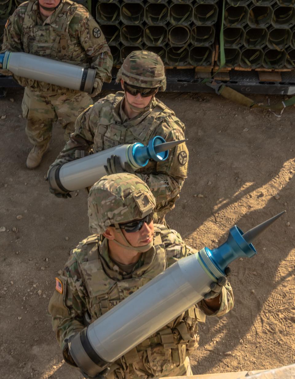 US Army soldiers carrying Sabot rounds to loaded onto an M1 Abrams