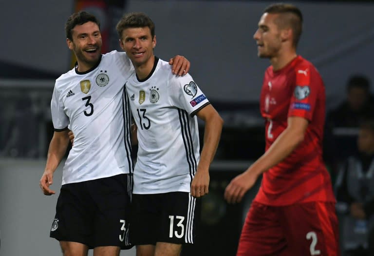 Germany's Thomas Mueller (C) is congratulated by teammate Jonas Hector after scoring a goal during their 2018 World Cup qualifier match against Czech Republic, in Hamburg, on October 8, 2016