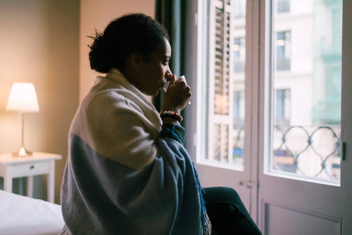 Woman drinking coffee and looking out the window