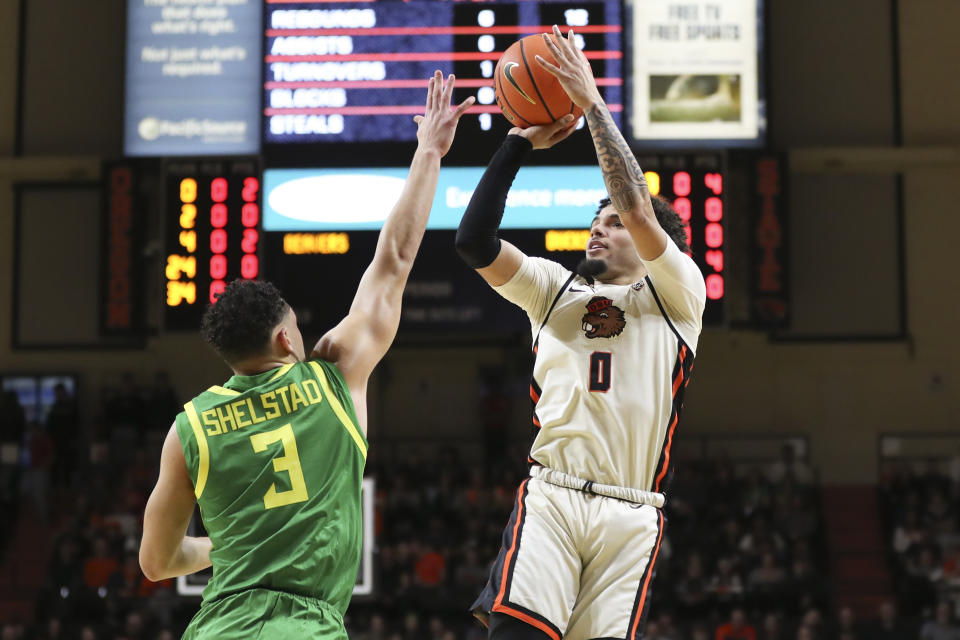 Oregon State guard Jordan Pope (0) shoots as Oregon guard Jackson Shelstad (3) defends during the first half of an NCAA college basketball game Saturday, Feb. 17, 2024, in Corvallis, Ore. (AP Photo/Amanda Loman)