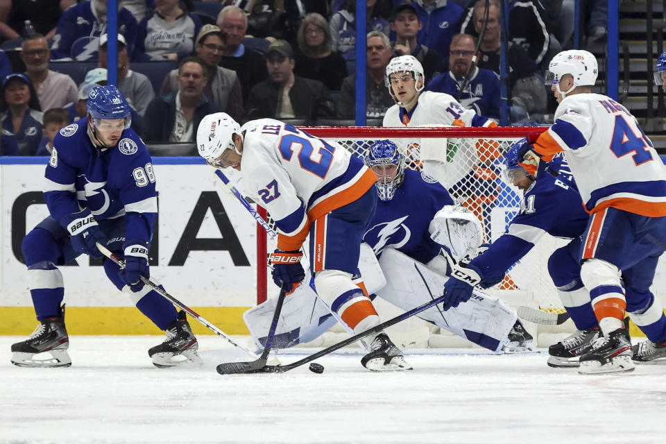 New York Islanders' Anders Lee (27) looks for a rebound in front of Tampa Bay Lightning goaltender Andrei Vasilevskiy as Mikhail Sergachev (98) and Pierre-Edouard Bellemare (41) defend during the second period of an NHL hockey game Monday, Nov. 15, 2021, in Tampa, Fla. (AP Photo/Mike Carlson)