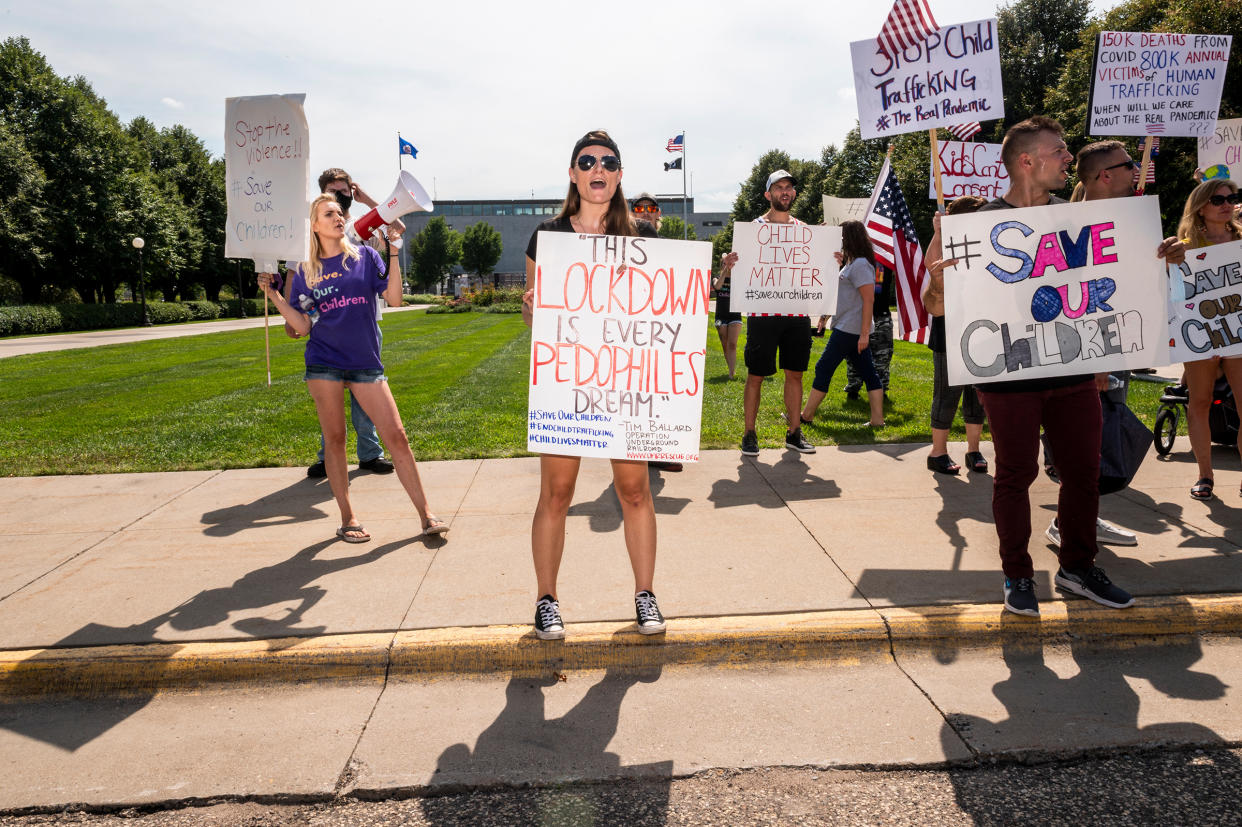 At an Aug. 22 “Save the Children” rally in St. Paul, Minn., protesters trumpet elements of the QAnon conspiracy theory