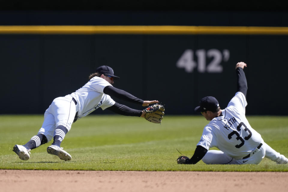 Detroit Tigers shortstop Zach McKinstry, left, and second baseman Colt Keith (33) reach for the single hit by Oakland Athletics' JJ Bleday during the fourth inning of a baseball game, Sunday, April 7, 2024, in Detroit. (AP Photo/Carlos Osorio)