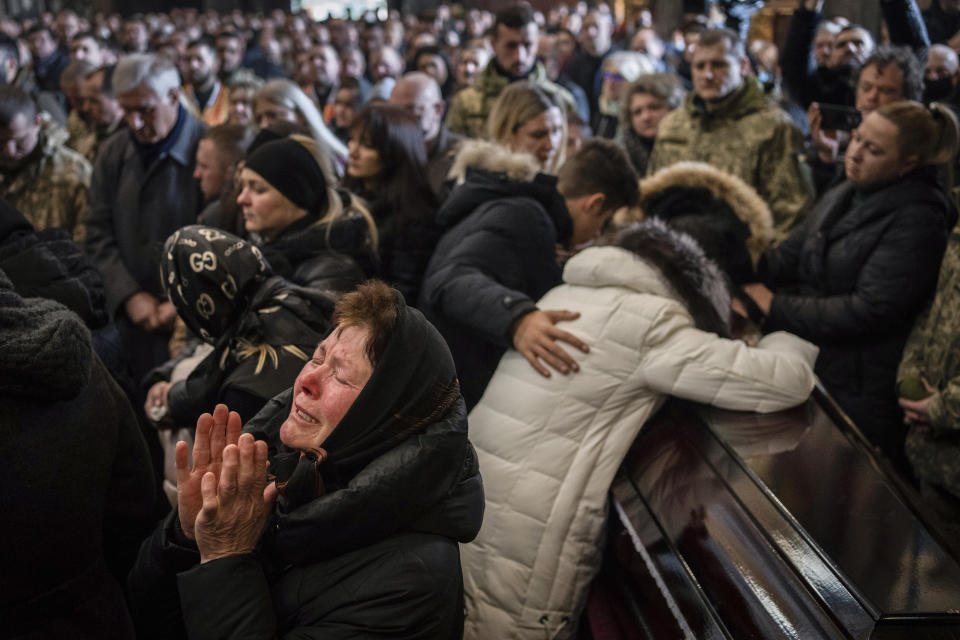 FILE - Relatives and friends attend a funeral ceremony for four of the Ukrainian military servicemen, who were killed during an airstrike in a military base in Yavoriv, in a church in Lviv, Ukraine, March 15, 2022. (AP Photo/Bernat Armangue, File)