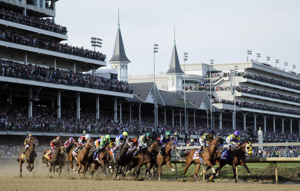 FILE- In this May 3, 2014, file photo, the field makes its way around the first turn during the 140th running of the Kentucky Derby horse race at Churchill Downs in Louisville, Ky. Jockeys competing in the rescheduled 146th Kentucky Derby have to arrive five days ahead and then quarantine upon returning to their home tracks, just one of many changes forced by the coronavirus pandemic. (AP Photo/Darron Cummings, File)