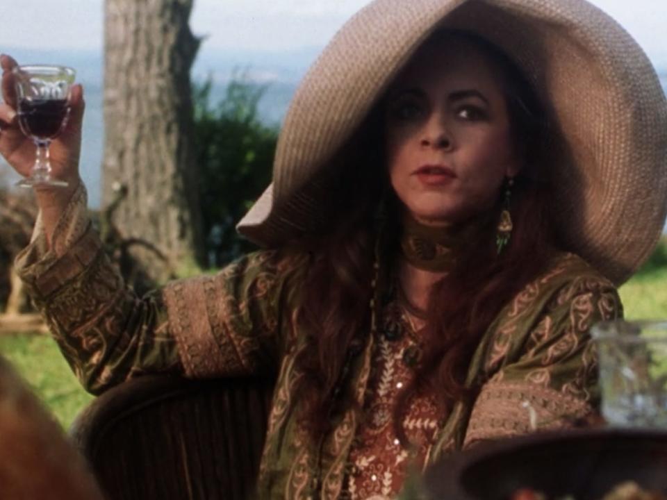 Aunt Frances drinking wine in a big sun hat in practical magic