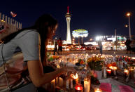 <p>Dashenka Giraldo of Las Vegas lights candles at a makeshift memorial for shooting victims at the Las Vegas Strip and Sahara Avenue in Las Vegas, Nev., Oct. 4, 2017. (Photo: Steve Marcus/Las Vegas Sun/Reuters) </p>