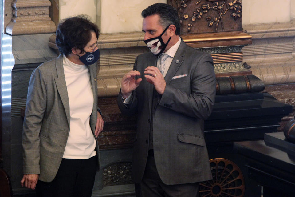 Kansas state Sen. Carolyn McGinn, left, R-Sedgwick, confers with Senate President Ty Masterson, R-Andover, at the start of a debate over a Republican plan for cutting Kansas income taxes, Tuesday, Feb. 9, 2021, at the Statehouse in Topeka, Kan. Democratic Gov. Laura Kelly has denounced the plan as "particularly irresponsible" during the COVID-19 pandemic. (AP Photo/John Hanna)