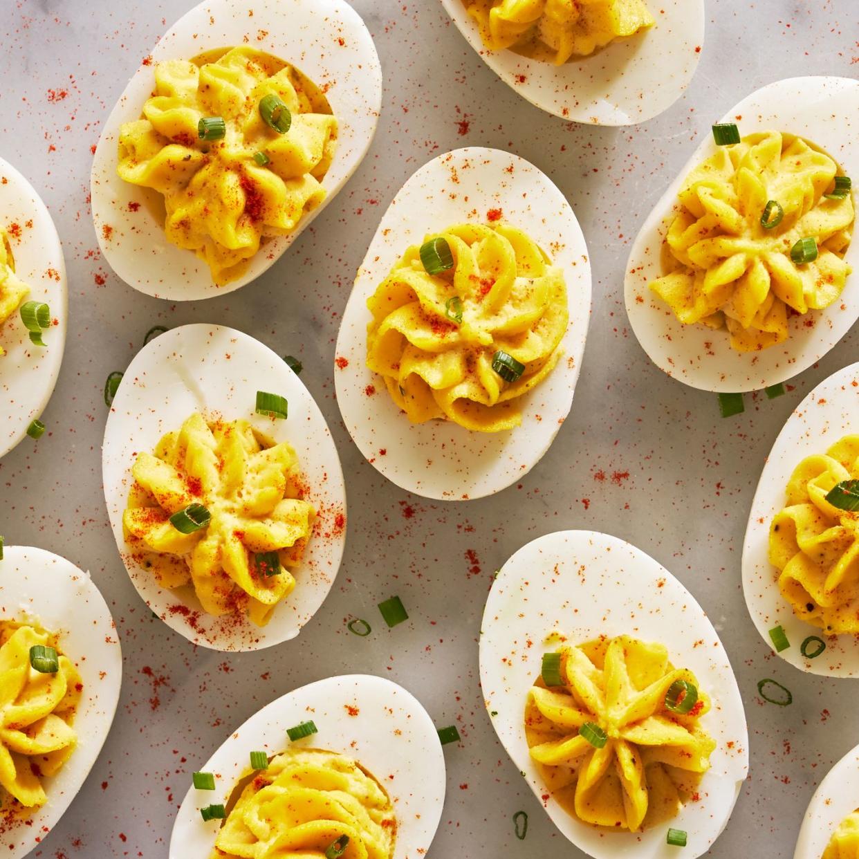 deviled eggs piped in a star shape with paprika and chives