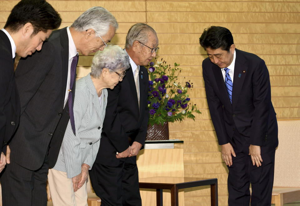 FILE - In this Sept 28, 2017, file photo, Japanese Prime Minister Shinzo Abe, right, bows to a group of families of Japanese citizens abducted by North Korea led by Shigeo Iizuka, second from right, prior to their meeting at Abe's official residence in Tokyo. Japan, which is still tormented by kidnappings of its citizens by North Korea decades ago and lies within easy striking distance of the North's missiles, has long wanted a deal. (Toshifumi Kitamura/Pool Photo via AP, File)
