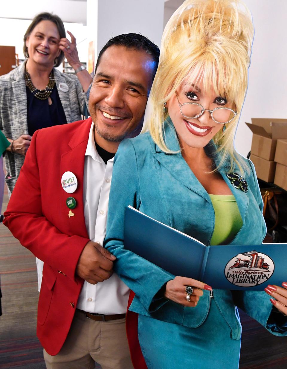 Ricardo Gutierrez, chairman of the Abilene Chamber of Commerce's Redcoats, poses with a life-sized cutout of Dolly Parton whose Imagination Library program was announced Wednesday at the Abilene Public Library South Branch May 10, 2023. Behind him is Julie Wilson who, with her husband Gary, sponsored the program with the United Way of Abilene.