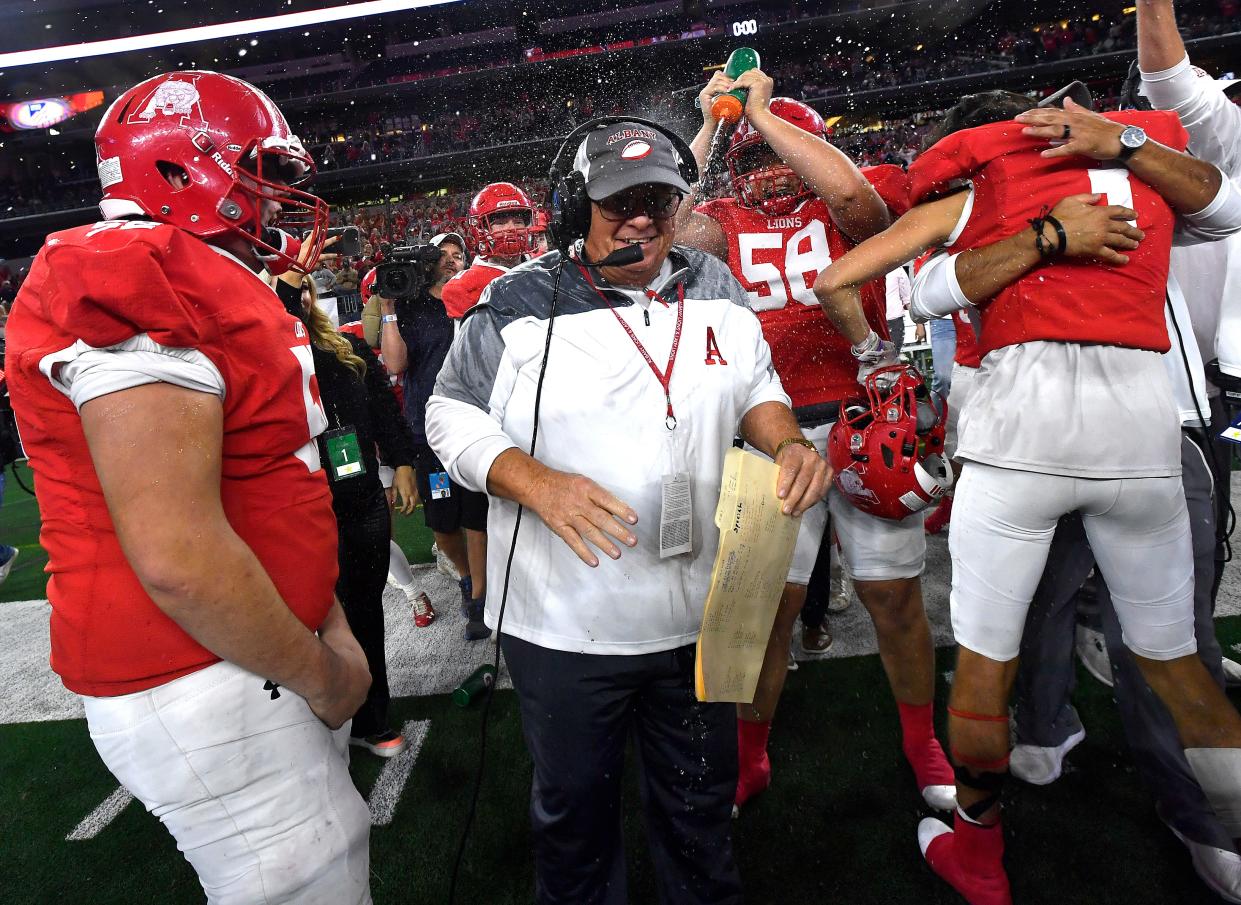 Albany linebacker Parker Shelton squirts coach Denney Faith with a water bottle as the Lions celebrate their UIL Class 2A Division 2 state football championship win over Mart on Wednesday at AT&T Stadium in Arlington.