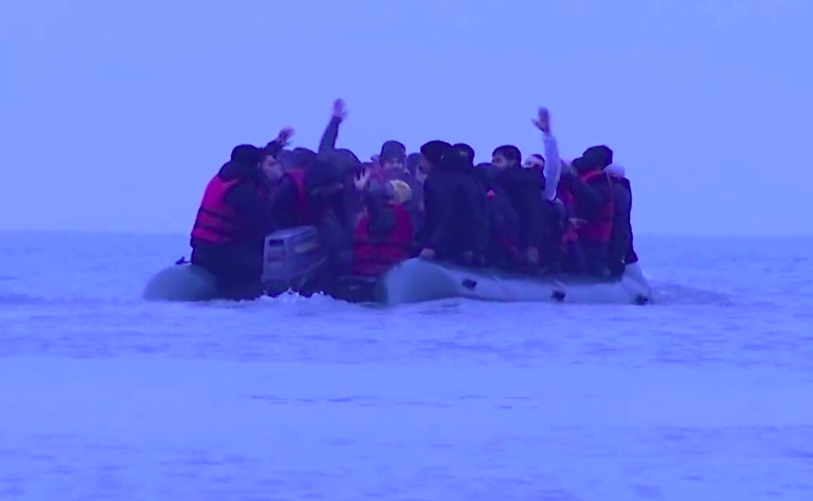 Migrants wave as they leave the French shore on their way to the UK. (Reuters)