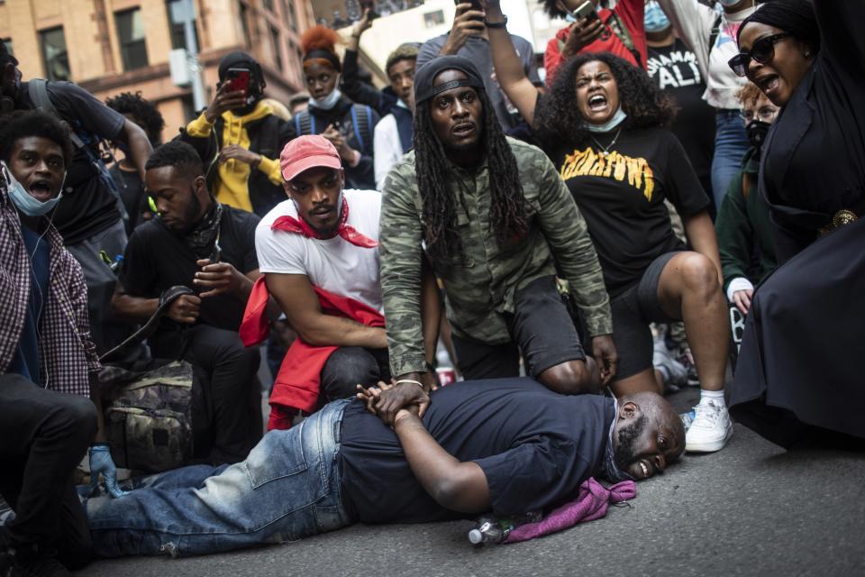 Protesters reenact the scene where George Floyd was restrained by police while marching in a solidarity rally calling for justice over the death of George Floyd Tuesday, June 2, 2020, in New York. Floyd died after being restrained by Minneapolis police officers on May 25. (AP Photo/Wong Maye-E)