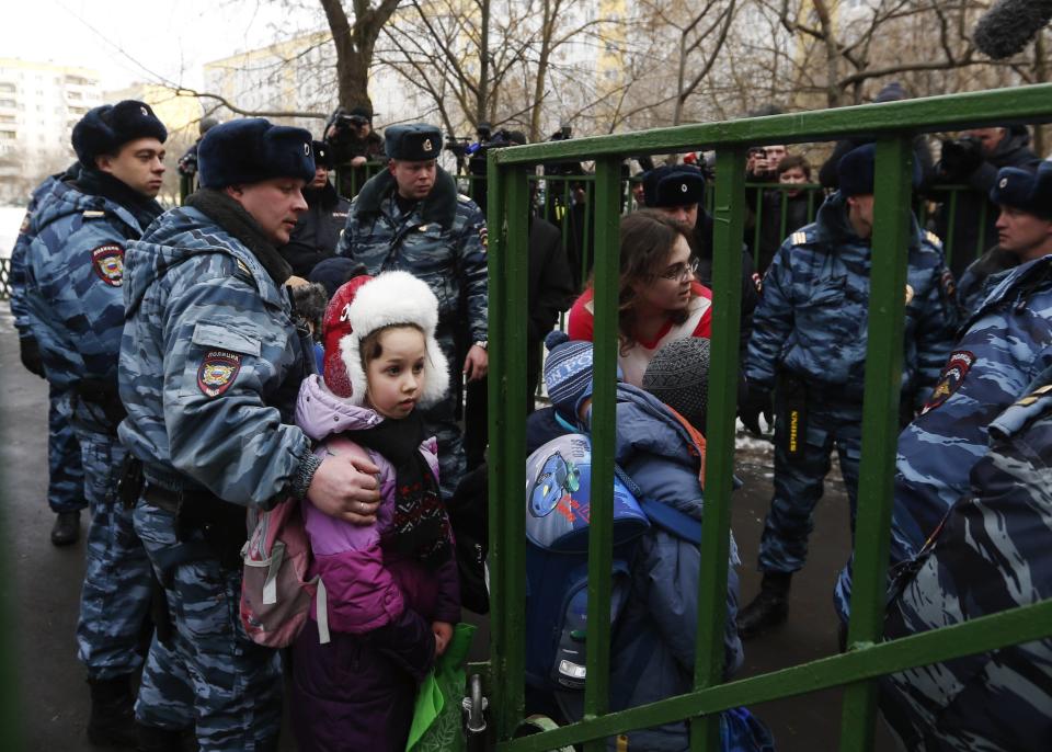 Children walk out of the premises of a high school, where a shooting incident has occurred, on the outskirts of Moscow, February 3, 2014. A Moscow high-school student shot a teacher and a police officer dead and held more than 20 other students hostage in a classroom on Monday before he was disarmed and detained, police said, just days before Russia hosts the Winter Olympics. (REUTERS/Maxim Shemetov)