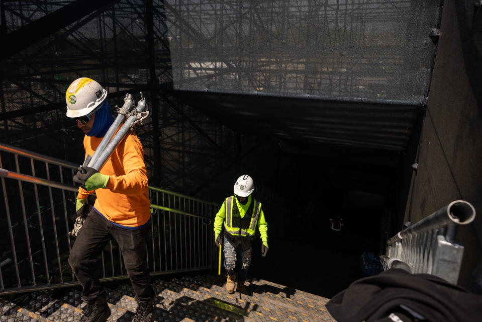 Construction workers carry equipments as they build the Nassau county International Cricket Stadium for the upcoming ICC Men's T20 World Cup in Eisenhower Park in East Meadow on May 1, 2024 in New York. Nassau County International Cricket Stadium under construction in Eisenhower Park in East Meadow, New York, ahead of the ICC T20 World Cup 2024. The newly-built Nassau County International Cricket Stadium, near New York, was launched on May 15, 2024 with the sport's world body 