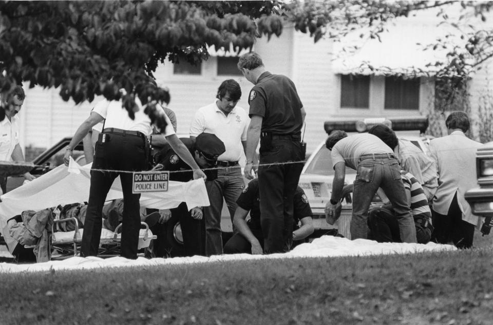 Police prepare to remove the body of a dead parachutist, Andrew Thornton, found in the front yard of a Knoxville man's residence, Sept. 11, 1985. Detectives said the victim had "a duffle bag of cocaine" with him.