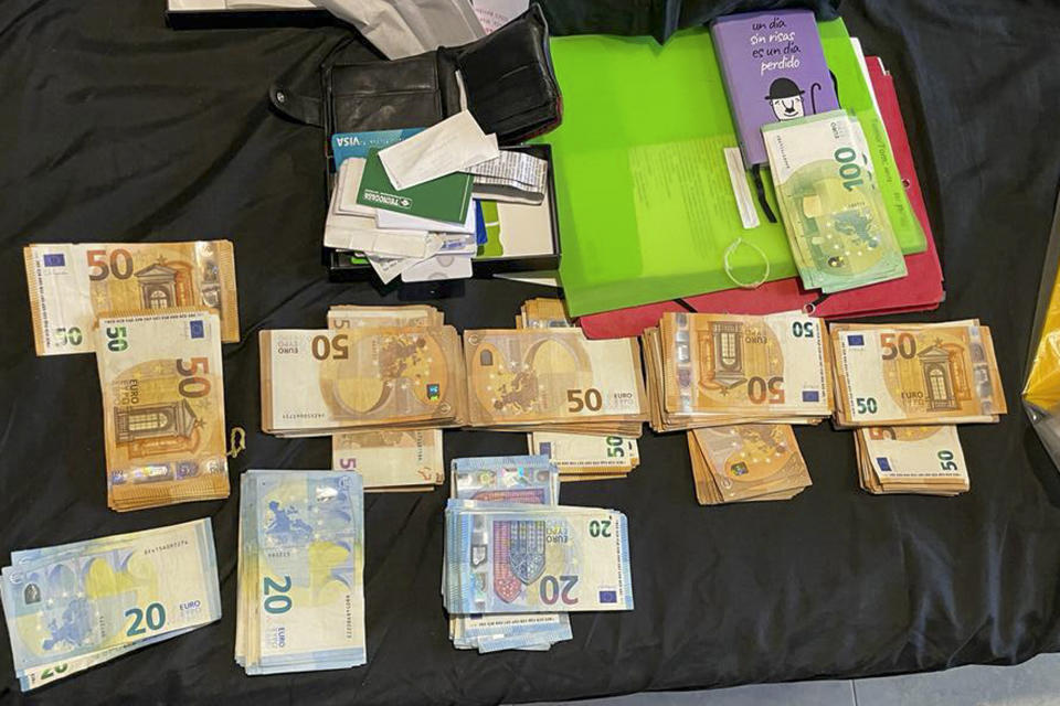 This photo provided by the Serbian Ministry of Interior on Monday July 24, 2023, shows seized money and documents in a raid. Serbian police said Monday they have arrested two people suspected of helping smuggling Cubans toward Spain as part of an international crime group. The suspects in Serbia are accused of organizing the illegal transfer of at least 53 people to neighboring countries — North Macedonia or Bosnia — and on to Spain. (Serbian Ministry of Interior via AP)
