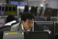 An employee of a foreign exchange trading company looks at monitors in Tokyo November 15, 2013. REUTERS/Toru Hanai