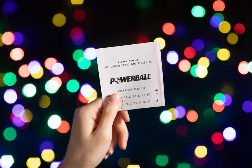 Lottery player holds up winning Powerball ticket. Source: The Lott