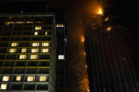 A fire burns at a construction site in Hong Kong, Friday, March 3, 2023. Hong Kong firefighters are battling the blaze that broke out at a construction site in the city's popular shopping district. (AP Photo/Louise Delmotte)