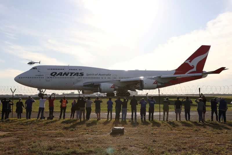 Personas observan el último avión Qantas 747 salir del aeropuerto de Sídney, Australia, el 22 de julio de 2020