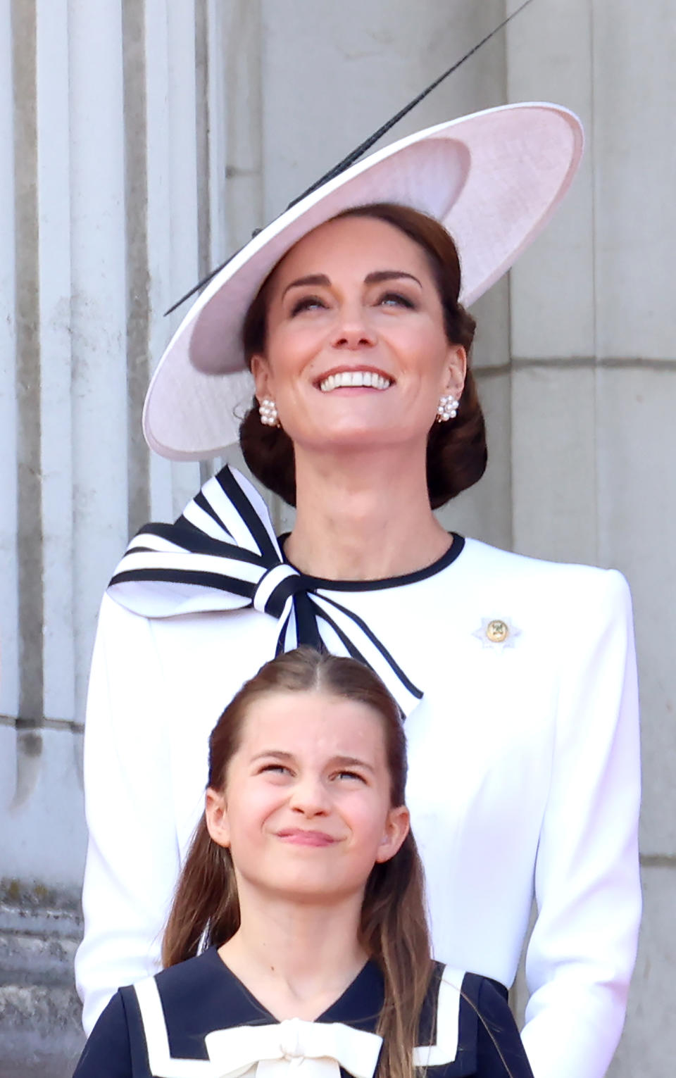Kate Middleton wears a stylish wide-brim hat and elegant outfit alongside Princess Charlotte, who is wearing a sailor-style dress