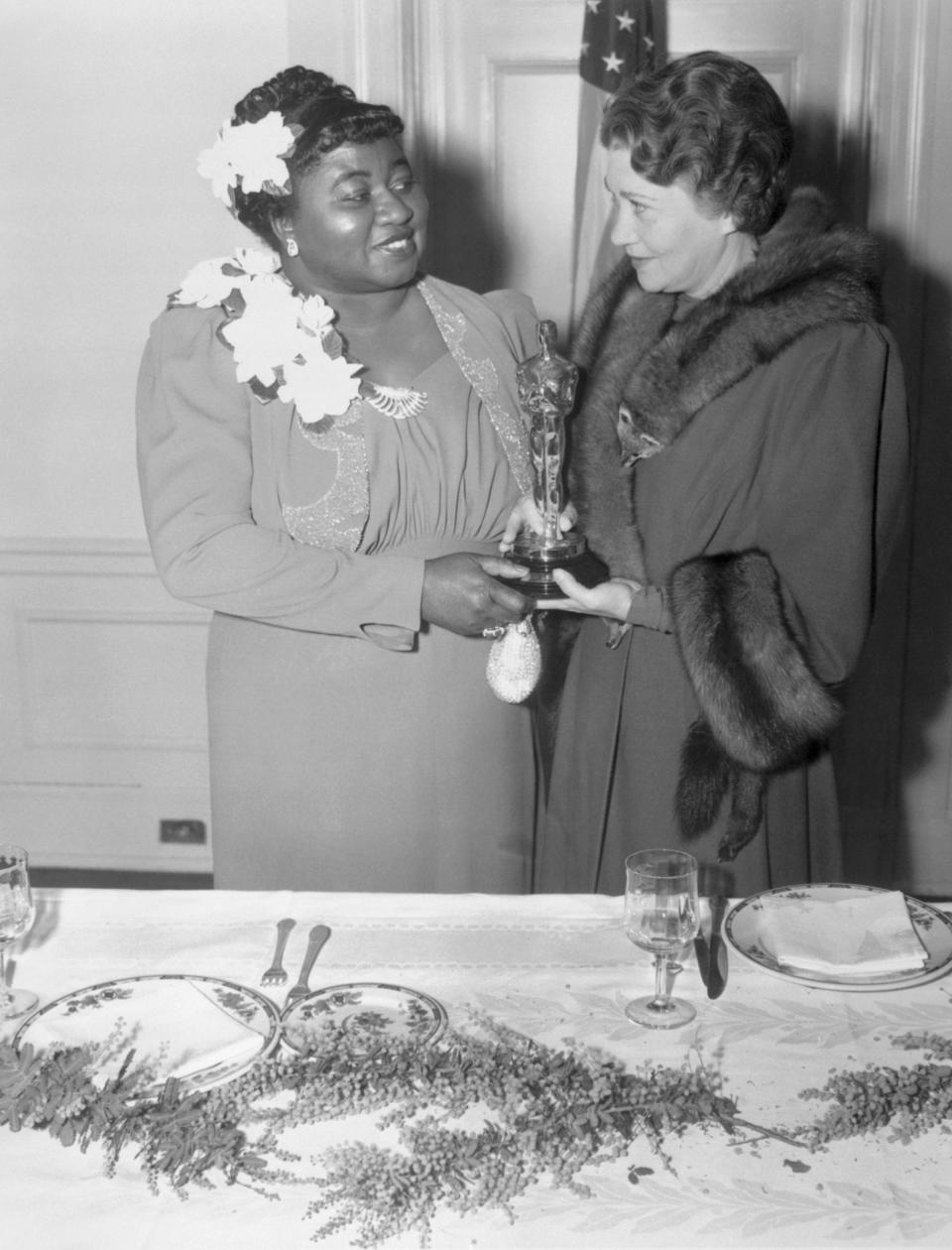 Hattie McDaniel accepts the Oscar, presented to her by Fay Bainter, for her supporting role in <em>Gone With the Wind</em> at the Twelfth Annual Banquet of the Academy of Motion Picture Arts and Sciences on Feb. 29, 1940.<span class="copyright">Bettmann Archive/Getty Images</span>