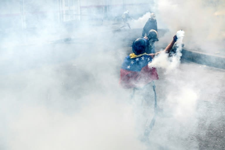 Opposition demonstrators clash with riot policemen during a health care personnel march in Caracas on May 22, 2017