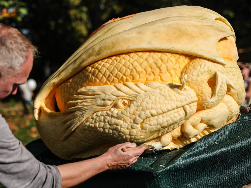 Artist Jeroen van de Vlag carves a dragon at the giant pumpkin carving festival in the blooming Baroque, the gardens around the Residenzschloss.