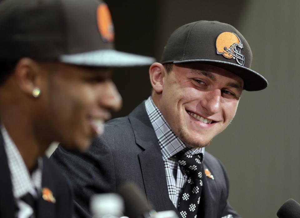 Cleveland Browns quarterback Johnny Manziel, right, from Texas A&M, watches cornerback Justin Gilbert during their introductory news conference at the NFL football team's facility in Berea, Ohio Friday, May 9, 2014. The Browns selected Gilbert with the eighth pick and Manziel with the 22nd pick in the first round of Thursday night's draft. (AP Photo/Tony Dejak)