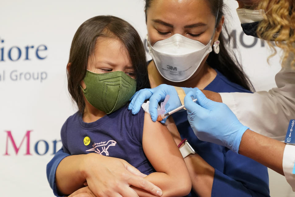 FILE - Maria Assisi holds her daughter Mia, 4, as registered nurse Margie Rodriguez administers the first dose of the Moderna COVID-19 vaccine for children 6 months through 5 years old, June 21, 2022, at Montefiore Medical Group in the Bronx borough of New York. Nearly 300,000 children under 5 have received a COVID-19 shot in the two weeks since they've been available, with the White House saying the slow pace of vaccinating the eligible population of about 18 million kids was expected. (AP Photo/Mary Altaffer, File)