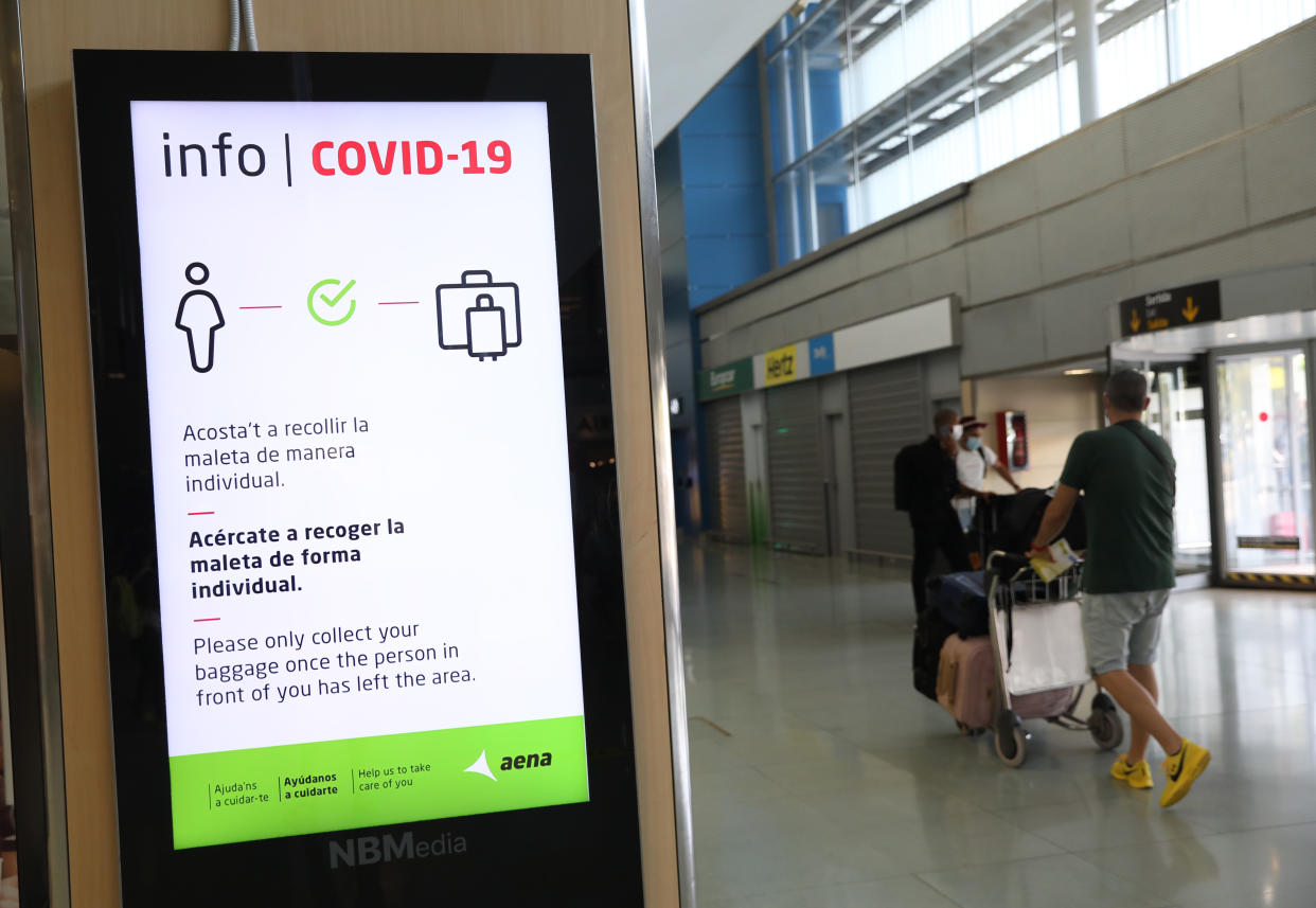 A Covid-19 information sign telling passengers to respect social distancing measures while checking their luggages at Ibiza international airport, Spain, where the tourism industry has been hit hard by the latest 14-day quarantine requirement by the British government for all tourists that travel from Spain because of its high levels of COVID-19 cases. Picture date: Saturday August 1, 2020.