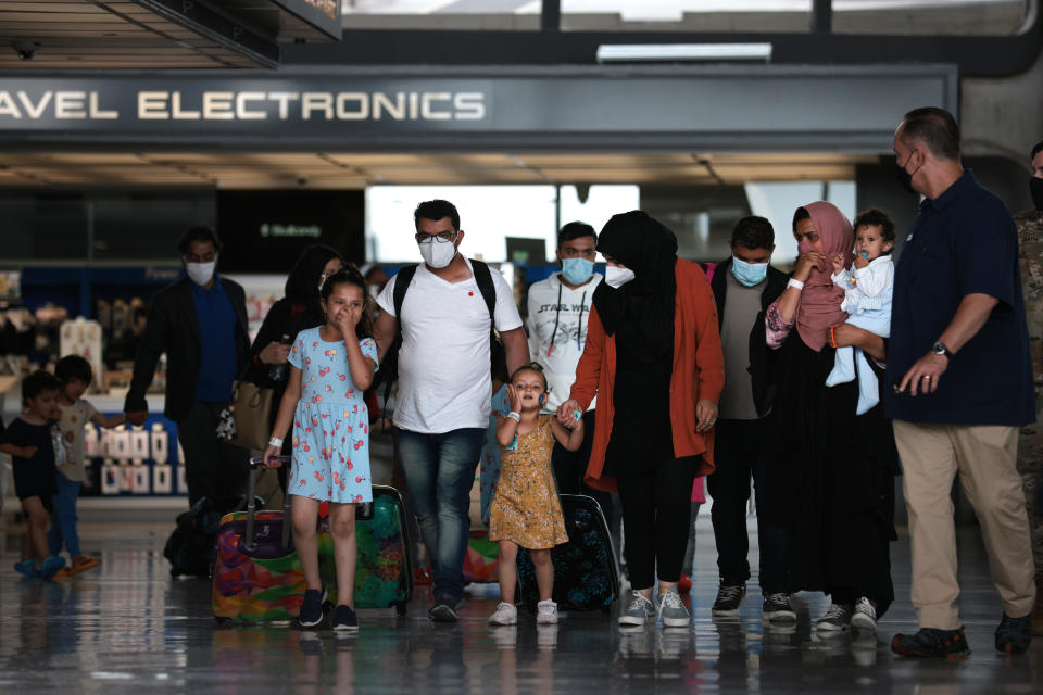 Refugees are led through the departure terminal to a bus at Dulles International Airport after being evacuated from Kabul following the Taliban takeover of Afghanistan on August 31, 2021, in Dulles, Virginia. / Credit: Anna Moneymaker / Getty Images
