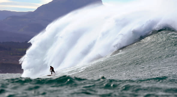 A man surfs the Belharra giant waves some two kilometers off the coast of the French basque country town of Urrugne on January 7, 2014. Thanks to certain climatic conditions in autumn and winter, a strong swell hits the Belharra Perdun underwater spur enabling a 10 to 15 metre wave to form. This wave is only surfed by experts who are towed out by a water scooter.    AFP PHOTO / GAIZKA IROZ        (Photo credit should read GAIZKA IROZ/AFP/Getty Images)