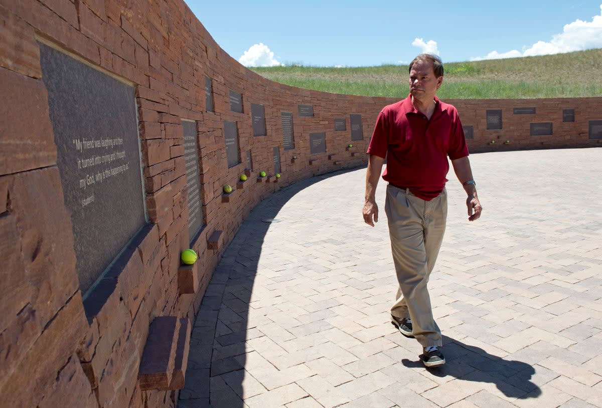 Tom Mauser, wearing his son Daniel's shoes, walks along a wall of the Columbine High School Memorial July 22, 2012 in Littleton, Colorado. Mauser, the father of Columbine High school shooting victim Daniel Mauser, has become an activist for increased gun control.  (AFP via Getty Images)
