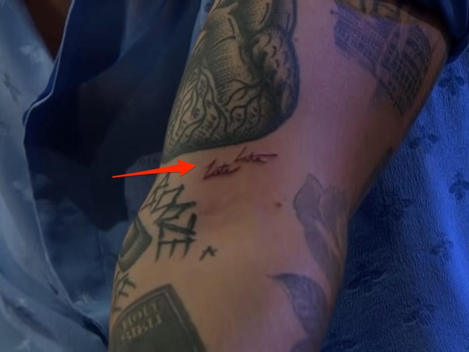 A red arrow pointing to Harry Styles' "Late Late" tattoo on his arm.