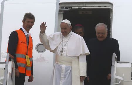 Pope Francis waves as he disembarks from the plane after arriving at Linate Airport in Milan, Italy, March 25, 2017. REUTERS/Stefano Rellandini