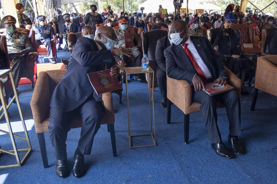 South African President Cyril Ramaphosa, right, speaks with former President Jacob Zuma, left, during the memorial service for Zulu King Goodwill Zwelithini in Nongoma, South Africa, Thursday, March 18, 2021. The monarch passed away early Friday after a reign that spanned more than 50 years. (AP Photo/PhilL Magakoe)