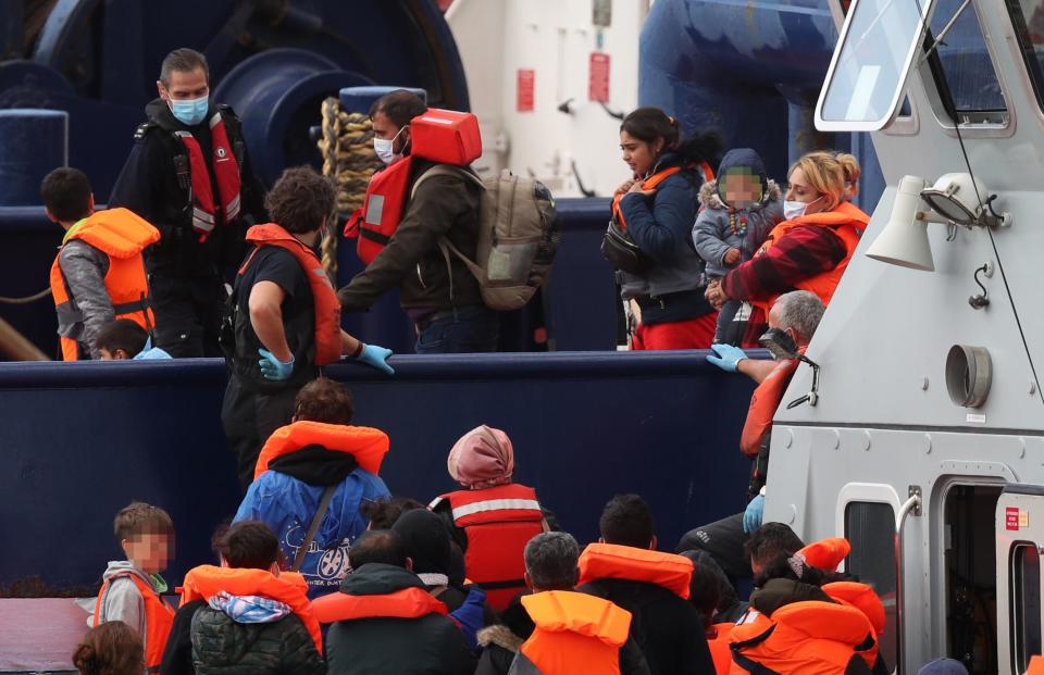 Migrants being helped ashore at Dover (PA)