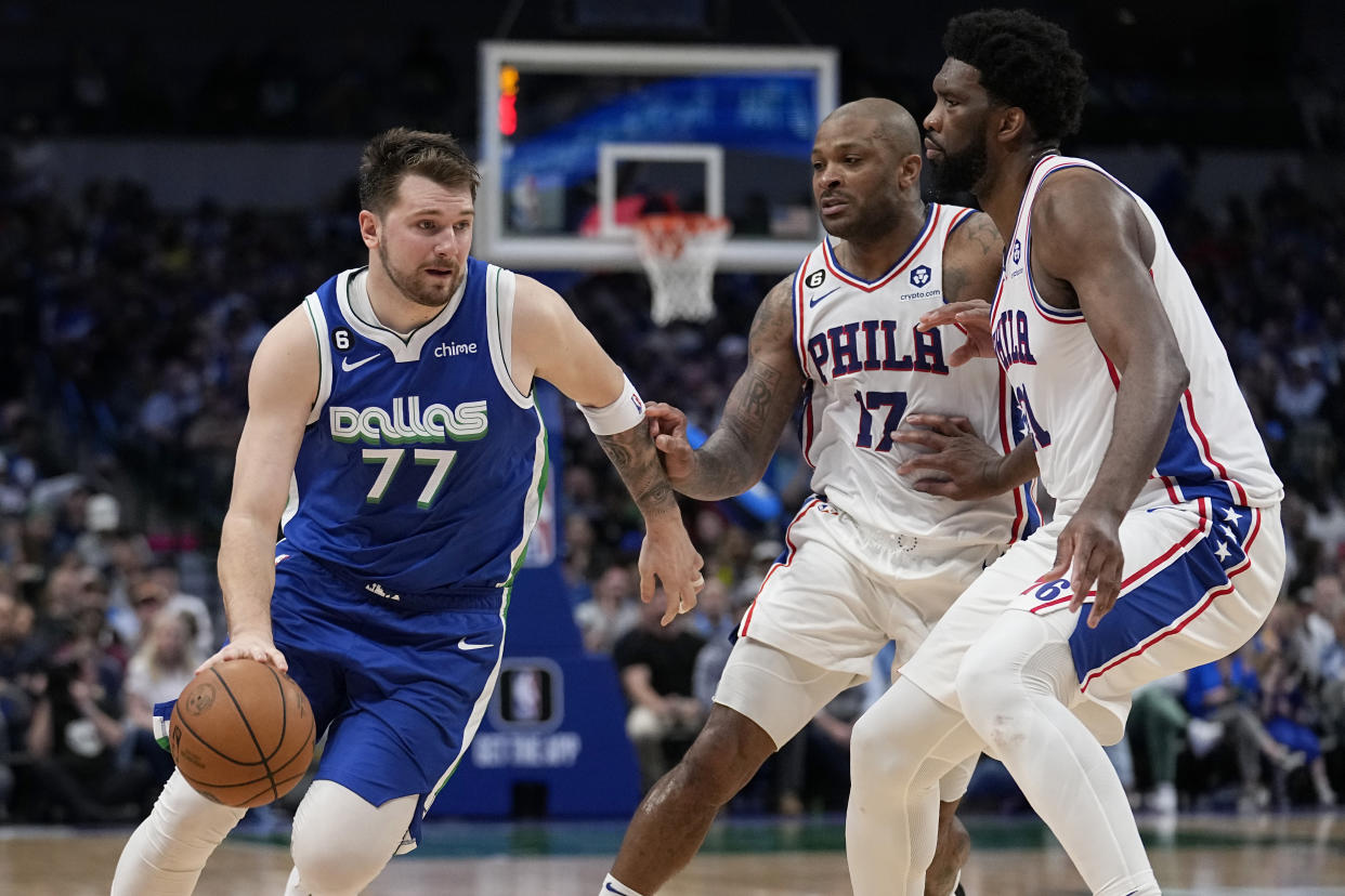 Dallas Mavericks' Luka Doncic (77) works to the basket as Philadelphia 76ers' P.J. Tucker (17) and Joel Embiid, right, defend in the second half of an NBA basketball game, Thursday, March 2, 2023, in Dallas. (AP Photo/Tony Gutierrez)