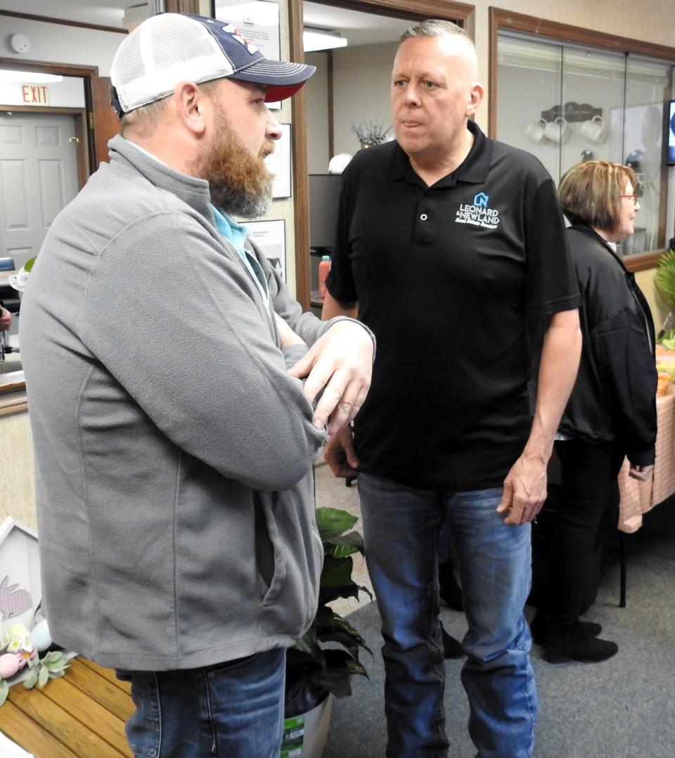 Mayor Mark Mills talks with Jeff Leonard at a ribbon-cutting and open house for the new Coshocton office of Leonard and Newland Real Estate Services. Based in Zanesville, it has offices across the region, with another opening soon in Newark.