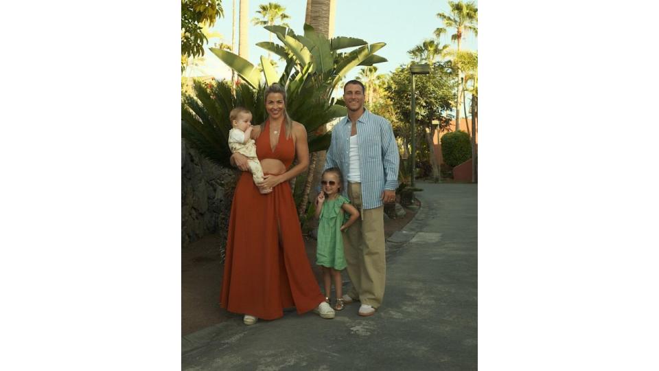 family of four posing outside in summer outfits 